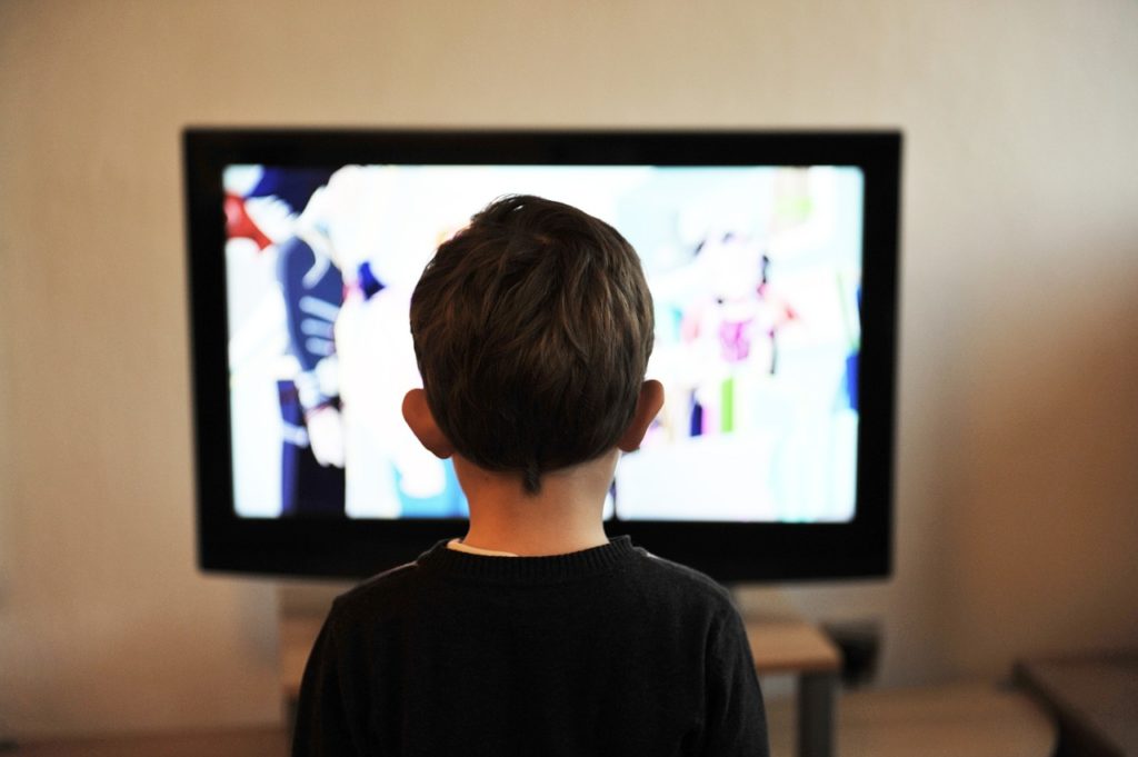 A male child facing a television