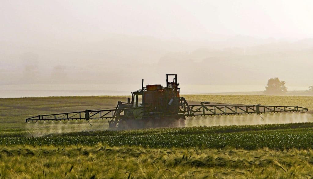 A field with pesticides being sprayed