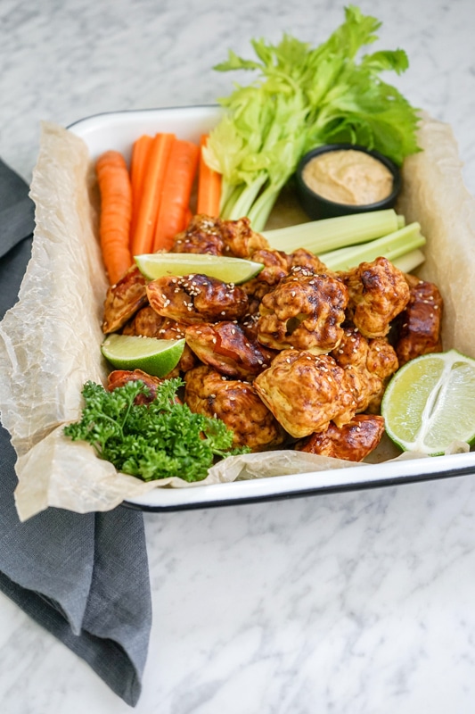 front view of a platter with cauliflower and carrot vegan wings and crudités
