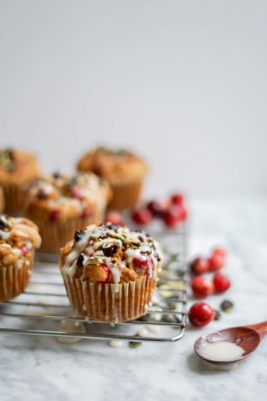 close-up of pumpkin cranberry muffins with icing dripping on top