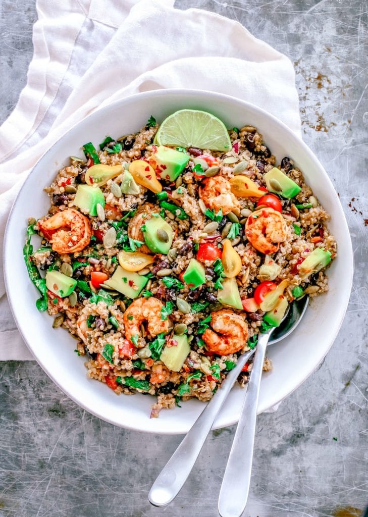 Aerial view of a large white bowl with quinoa and shrimp salad